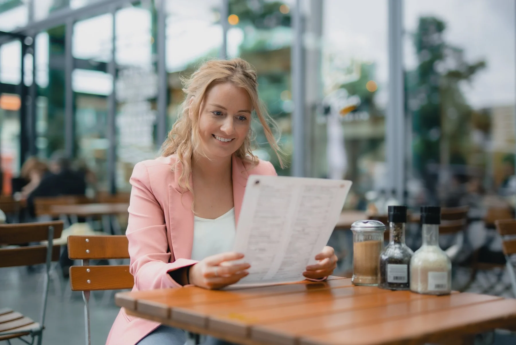 Client lisant un menu à une table de terrasse