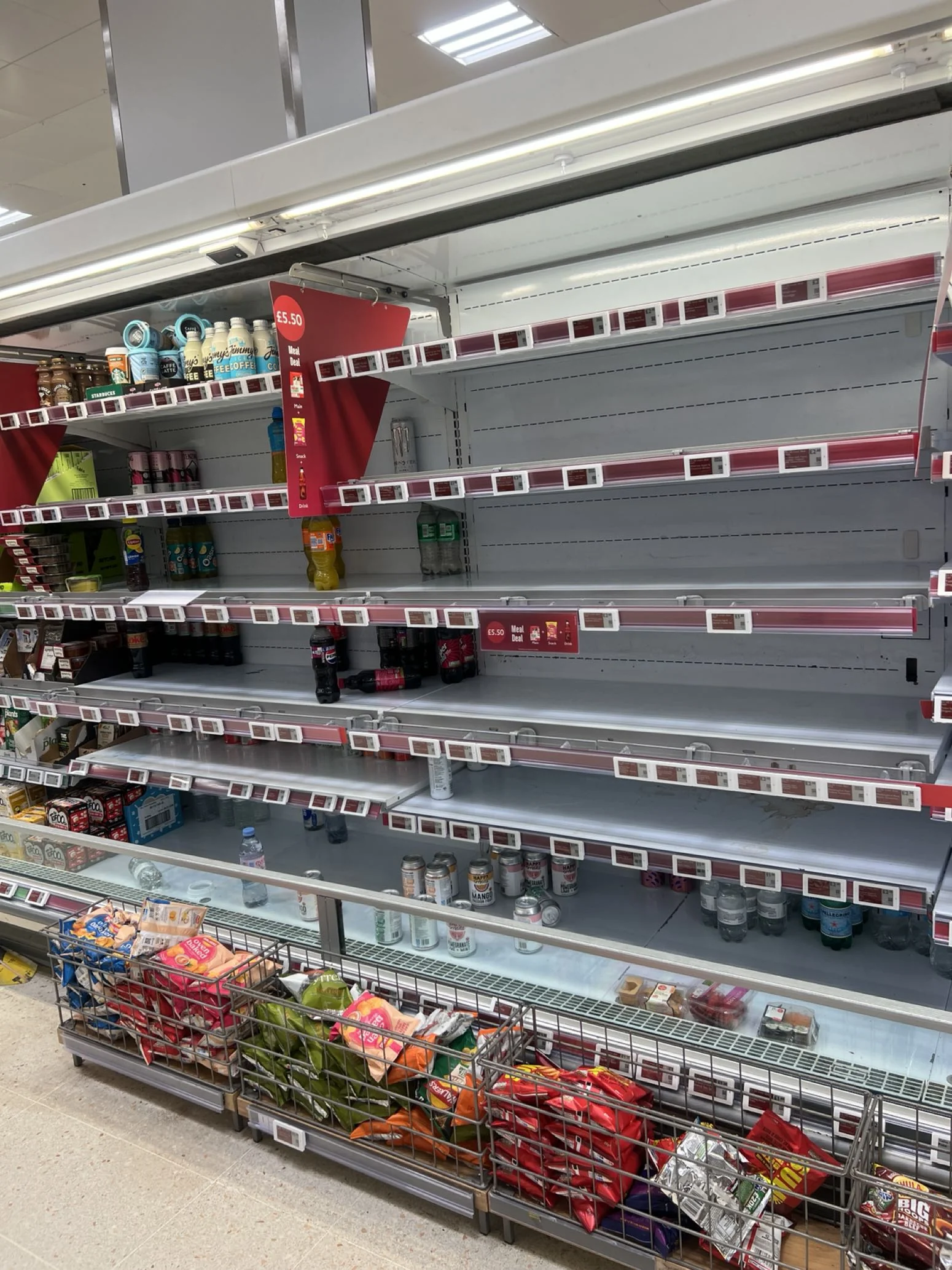 Kühlregale im Supermarkt mit mehreren fast leeren Reihen