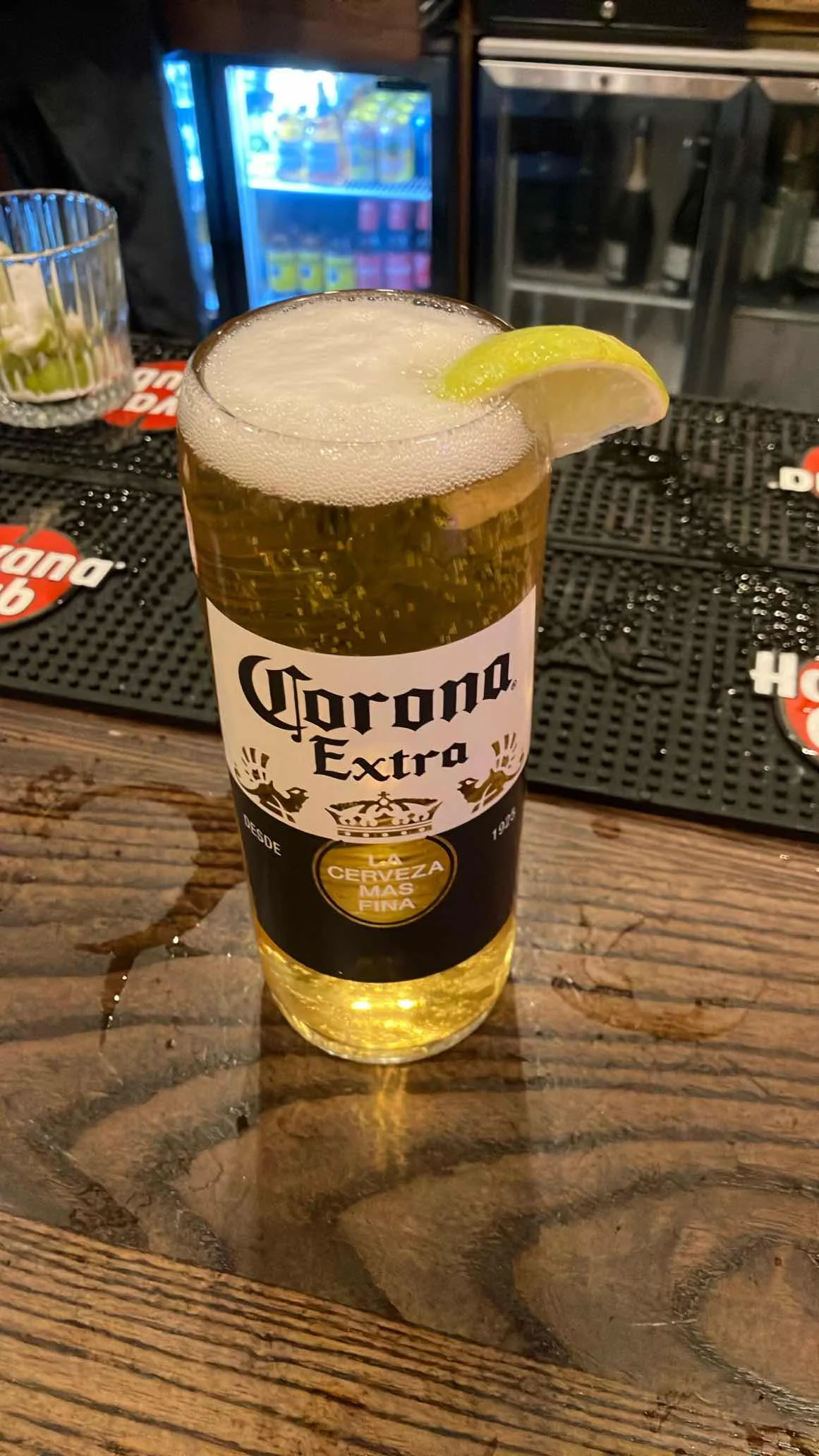 Corona Extra served in the correct branded glass, with the lime wedge positioned on the rim
