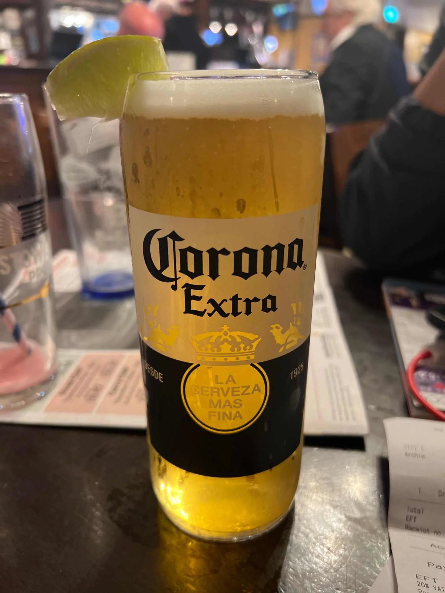 Corona Extra served in the correct branded glass, with the lime wedge positioned on the rim