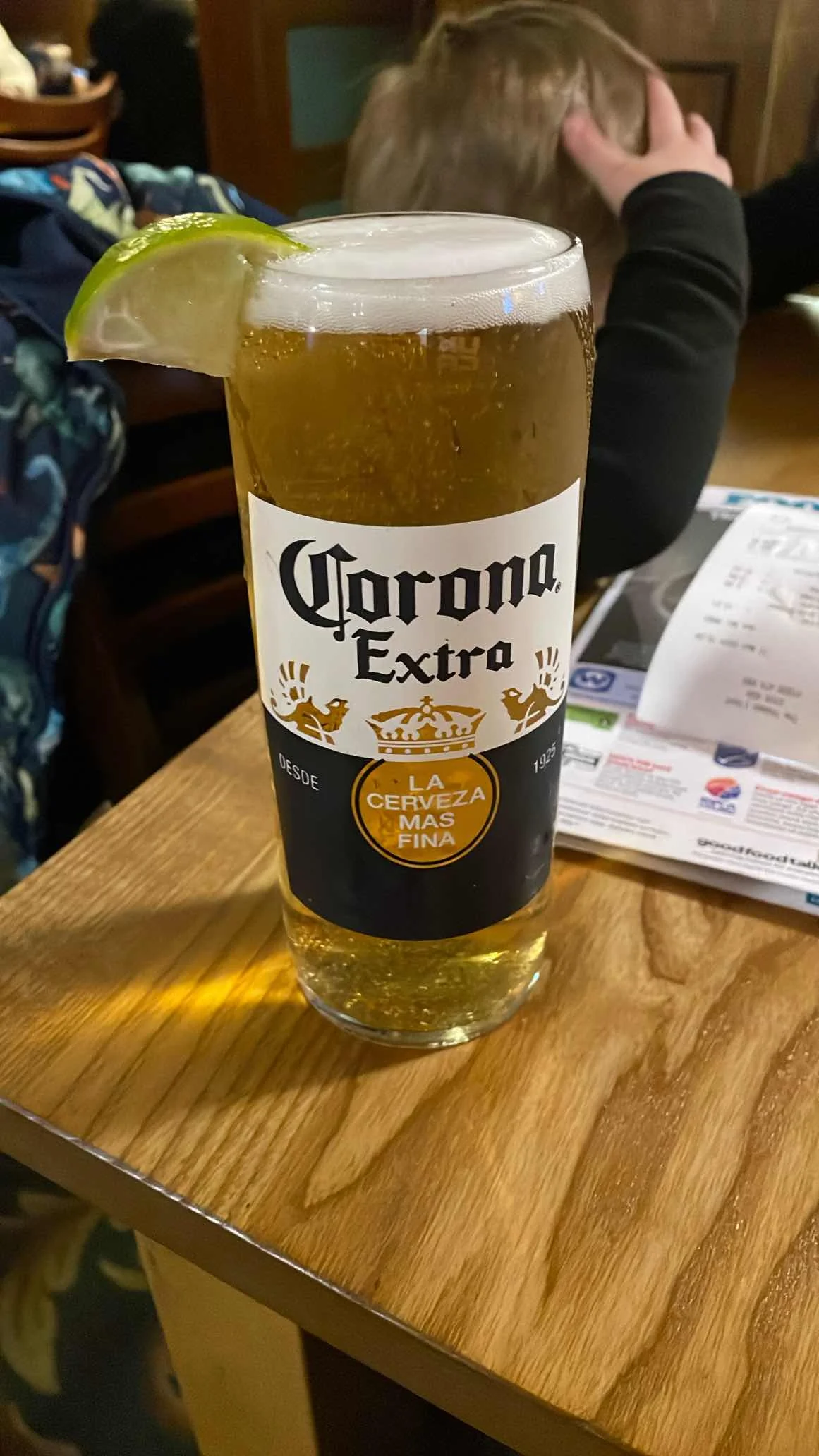 Corona Extra served in the correct branded glass, with the lime wedge positioned on the rim